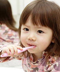 child brushing teeth with fluoride-free toothpaste