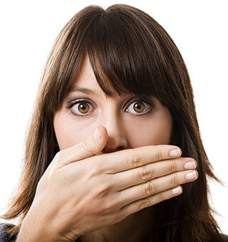 A girl covering her mouth because of halitosis