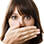 woman covering her mouth because of halitosis