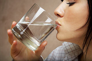 A woman drinking a glass of water