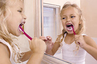 a little girl brushing her teeth