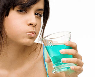 a girl swishing mouthwash