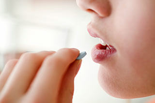 Woman taking an oral probiotic